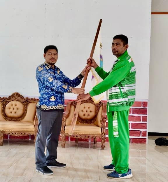 Foto Plt. Kadispora Halsel Suhdan Kasuba Menyerahkan bendera Kepada Ketua Rombongan.